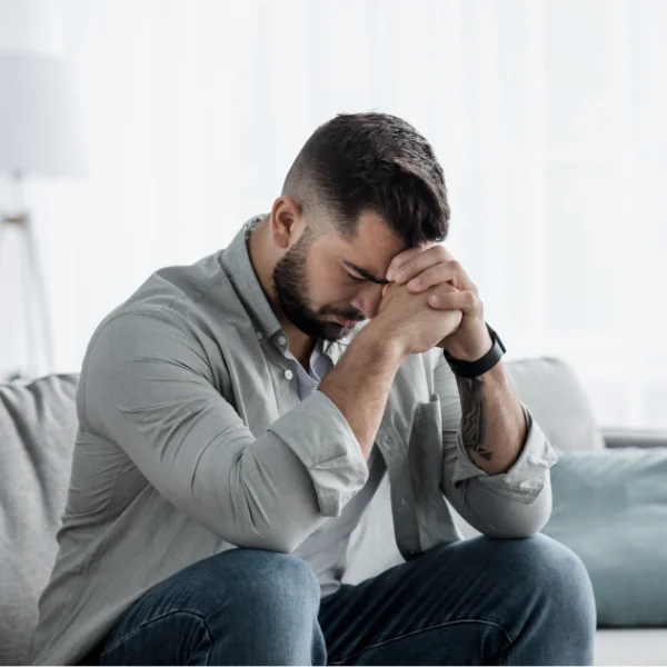 Man experiencing anxiety and emotional distress while sitting at home