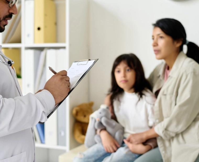 Doctor consulting with mother and child for respiratory or asthma evaluation